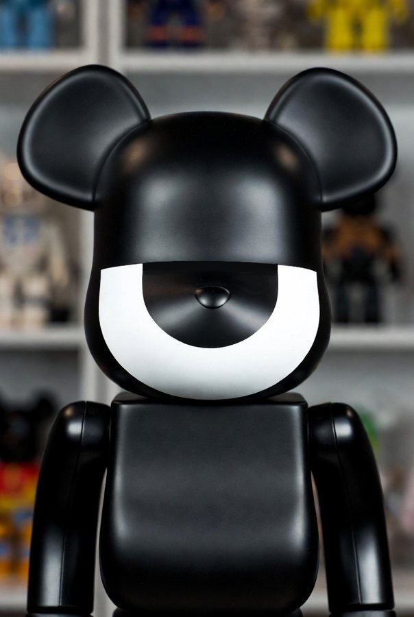 A black vinyl art toy with da-eYe's white crescent across its face