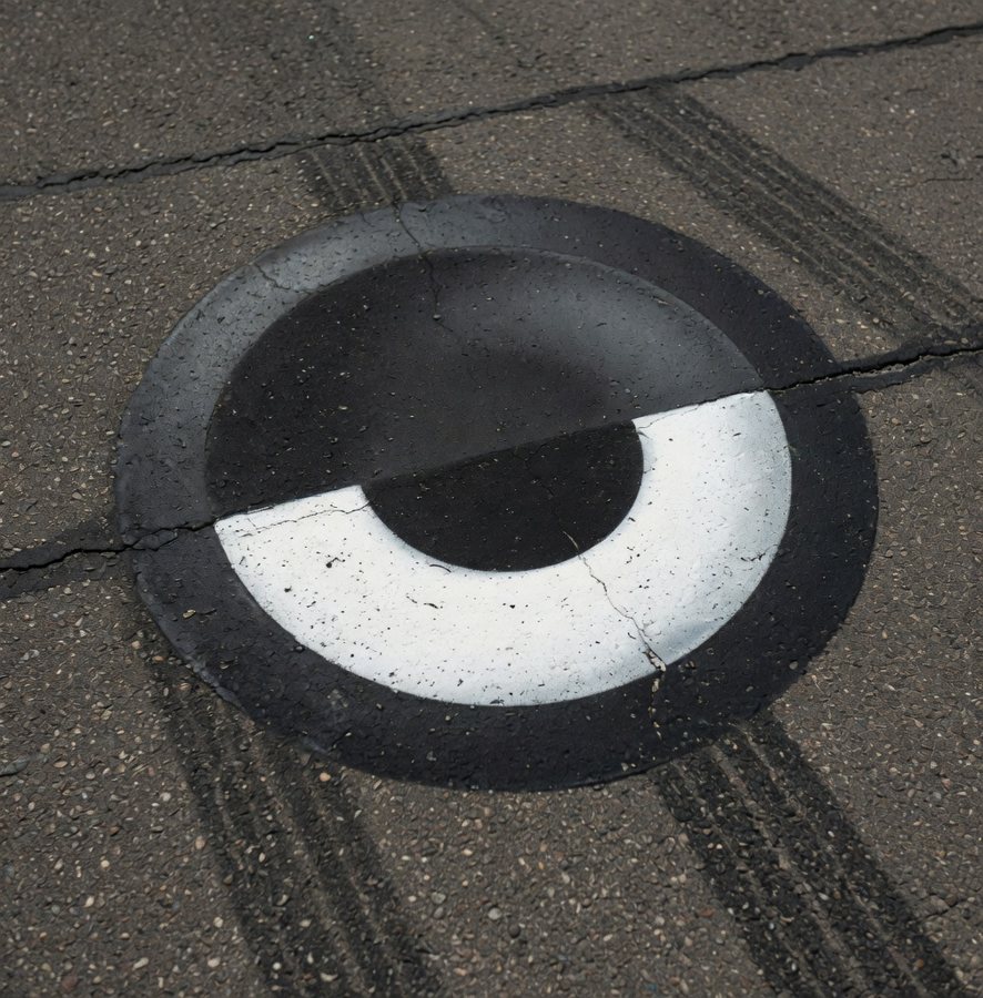 da-eYe painted on cracked asphalt, crossed by tire marks